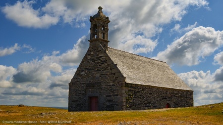 Eine alte Steinkirche, einsam in einer rauhen Berglandschaft